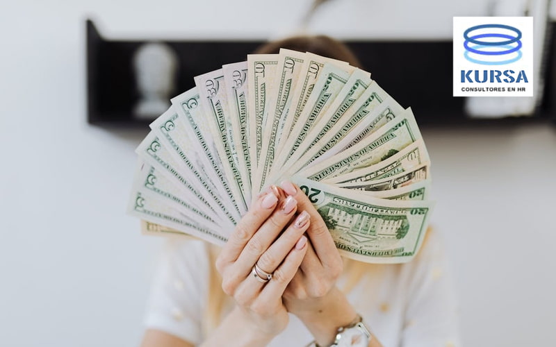 Abanico de billetes de dólares representando estudios de mercado salarial para evaluar competitividad externa y estrategias de remuneración empresarial